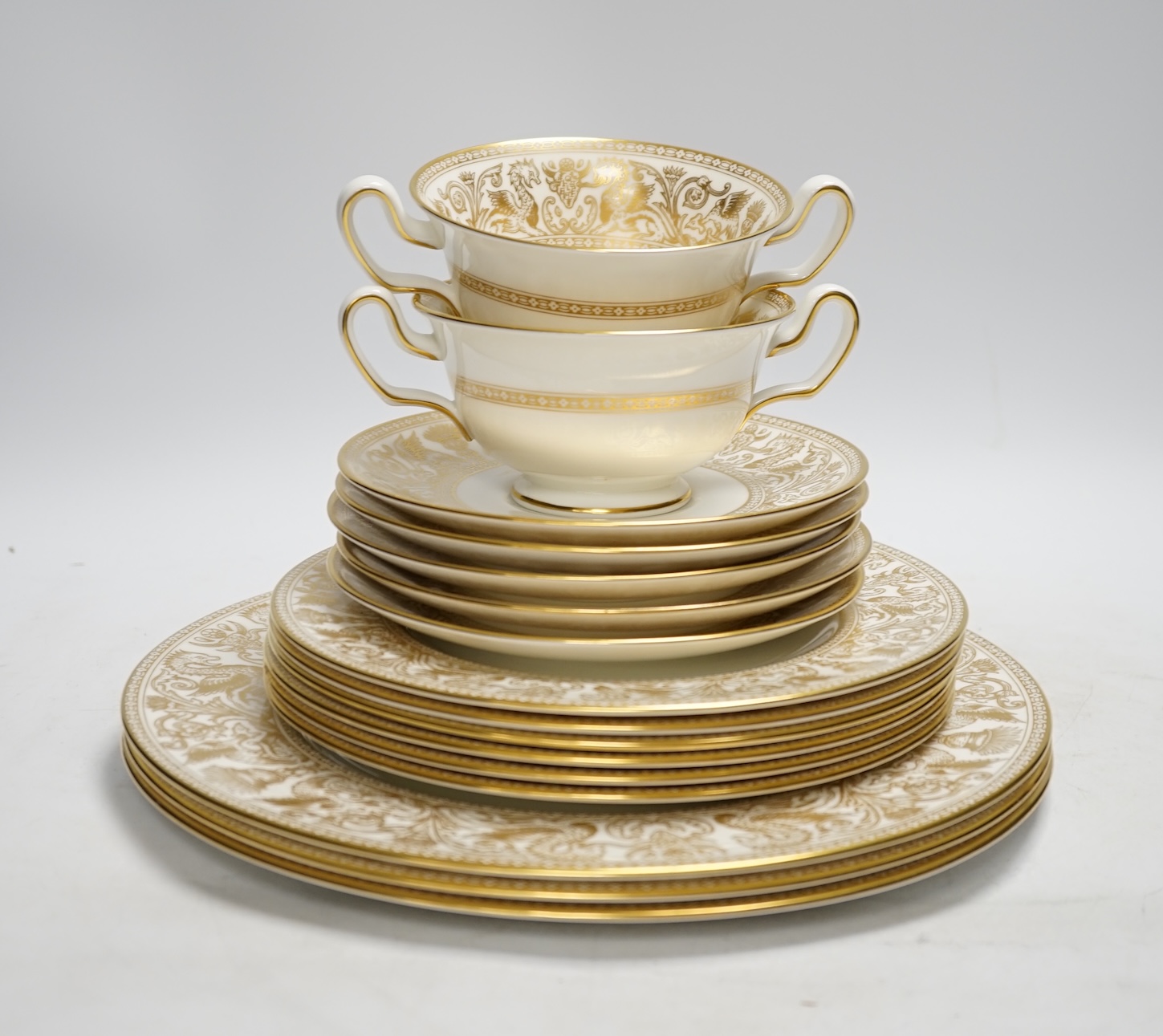 A Wedgwood bone china gold Florentine part dinner service, including an oval dish, twin handled cups and plates, largest 35cm wide